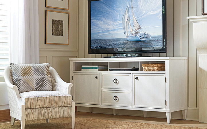 Ocean Breeze living room features a media console and an upholstered chair.