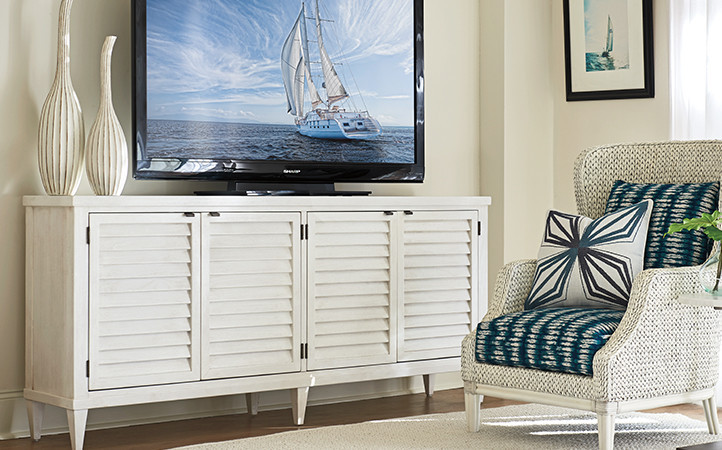 Ocean Breeze living room features a white media console and a white chair upholstered with a multi-color fabric.