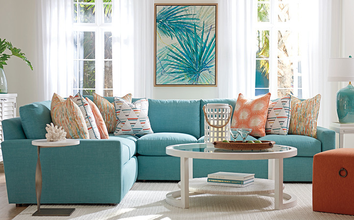 Ocean Breeze living room features a teal sectional, end table, accent table, cocktail table, and an orange small ottoman.