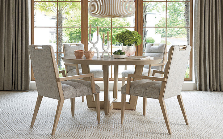 Sunset Key dining room scene featuring round dining table with side and arm chairs.